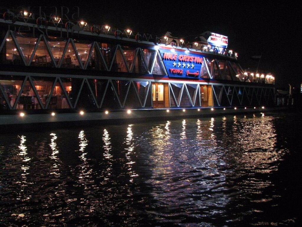 Am frühen Abend startet Ihr unvergessliches Highlight – die Nil-Dinner-Cruise. An Bord eines stilvollen Kreuzfahrtschiffes gleiten Sie sanft über den legendären Nil, während sich die Lichter von Kairo im Wasser spiegeln. Das elegante Schiff ist mit großzügigen Außendecks ausgestattet, die Ihnen einen freien Blick auf die beleuchteten Uferpromenaden, das moderne Stadtbild und die historischen Gebäude bieten.