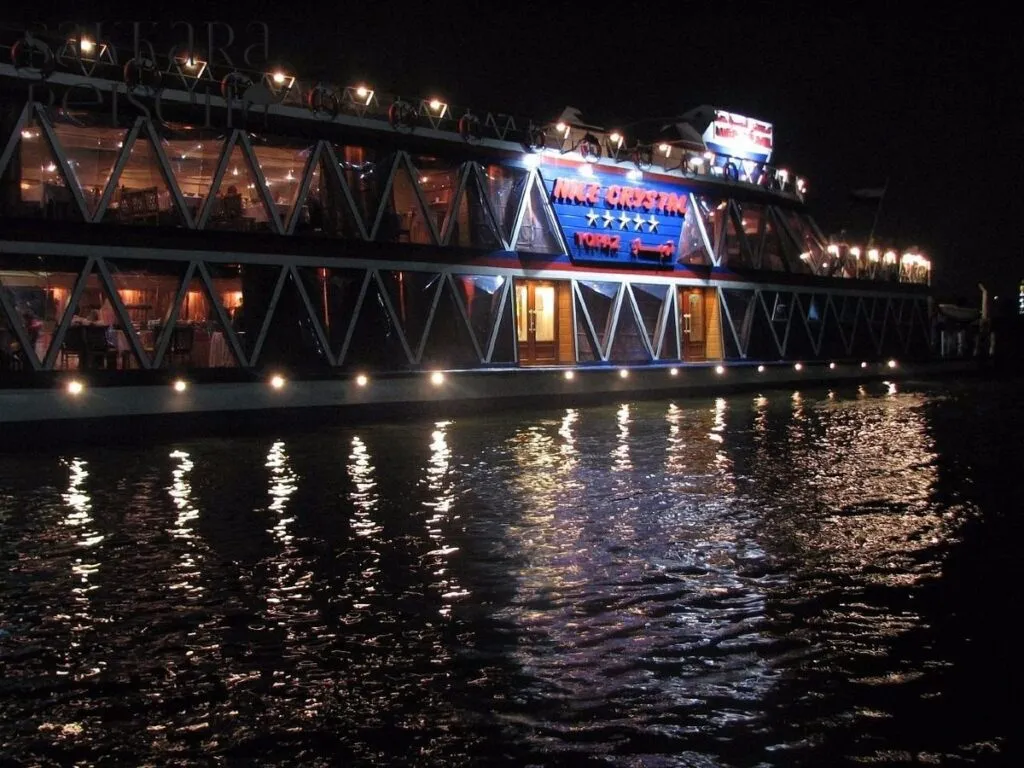 Am frühen Abend startet Ihr unvergessliches Highlight – die Nil-Dinner-Cruise. An Bord eines stilvollen Kreuzfahrtschiffes gleiten Sie sanft über den legendären Nil, während sich die Lichter von Kairo im Wasser spiegeln. Das elegante Schiff ist mit großzügigen Außendecks ausgestattet, die Ihnen einen freien Blick auf die beleuchteten Uferpromenaden, das moderne Stadtbild und die historischen Gebäude bieten.